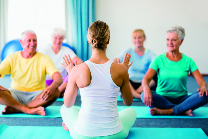 Instructor performing yoga with seniors