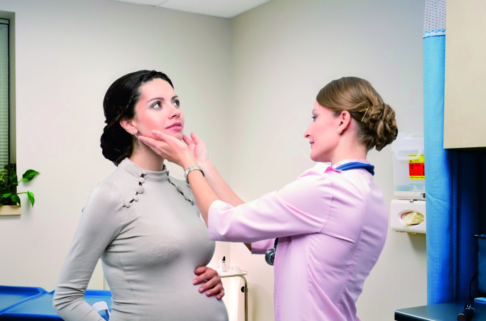 Doctor endocrinologist checking thyroid pregnant